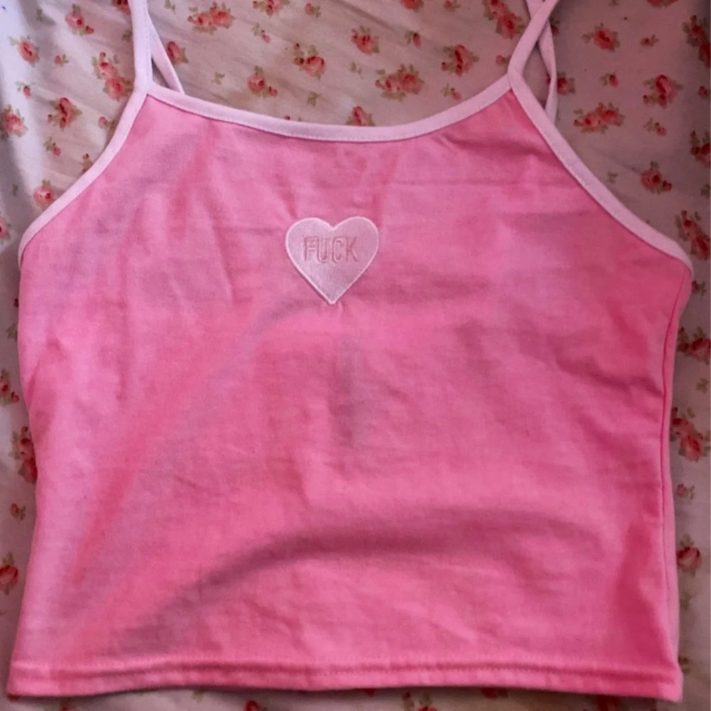 A cute crop top pastel pink has the f word on it.